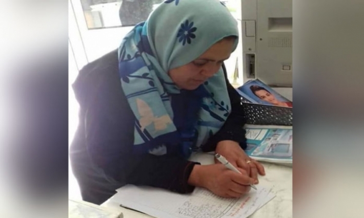 صورة والدة المرحوم عمر العبيدي أثناء المساهمة في الحساب البنكي تثير إعجاب جماهير الأحمر والأبيض
